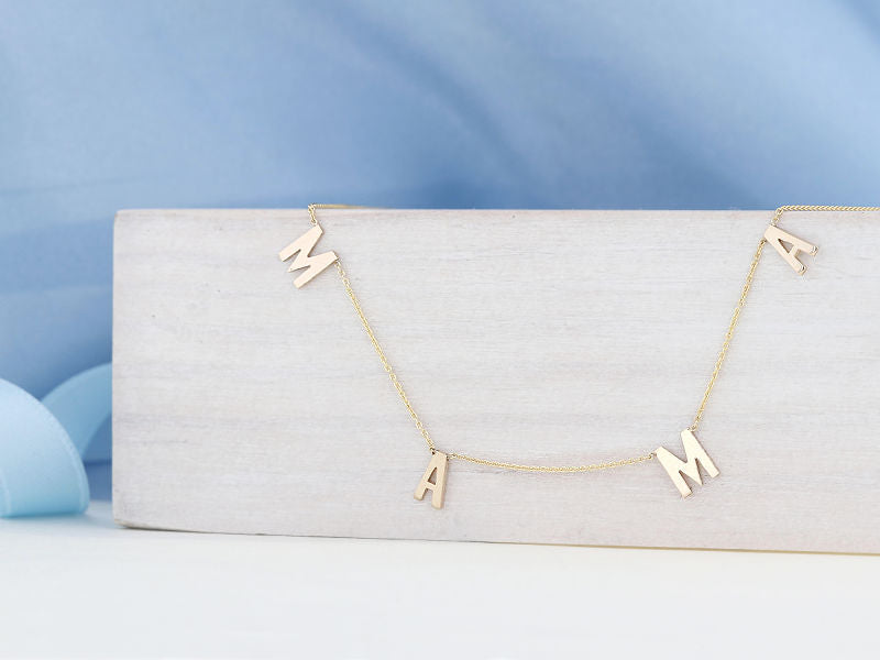 14k Yellow gold "MAMA" Necklace artistically displayed