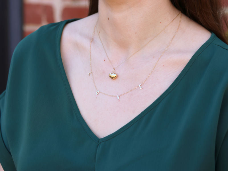 14ky "LOVE" and puffed heart necklace on a neck