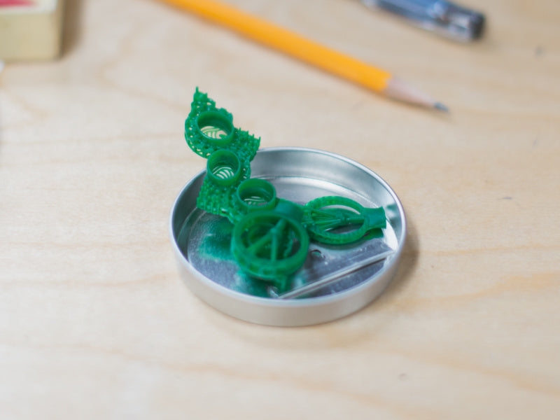 Two 3D printed rings and a 3D printed pendant in resin, one of the steps of making custom jewelry.