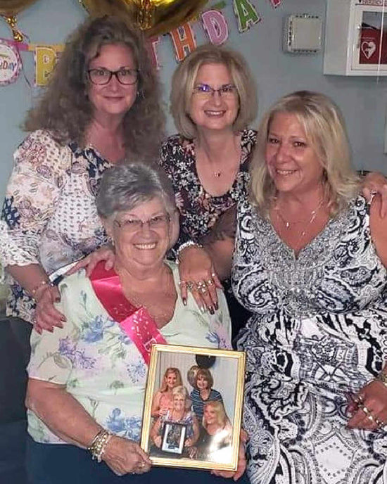 Angela Goliber with her family holding another picture of her and her family
