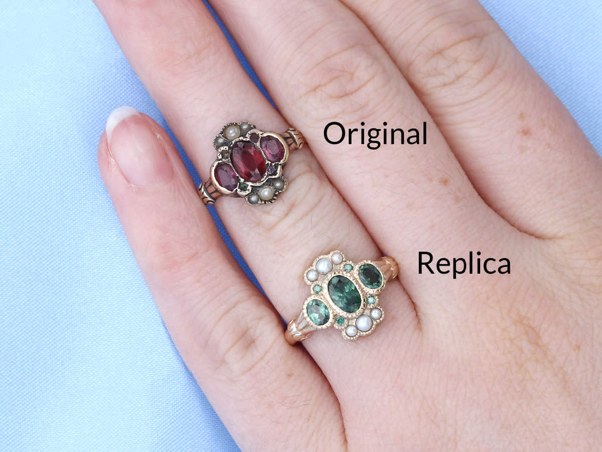 An original eduardian ruby and pearl ring with worn metal and damaged and missing stones, next to a new replica using green sapphires instead of rubies.