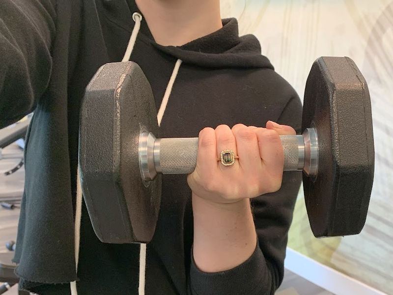 A person lifting weights while wearing a ring.