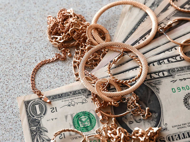 Rose gold jewelry on money