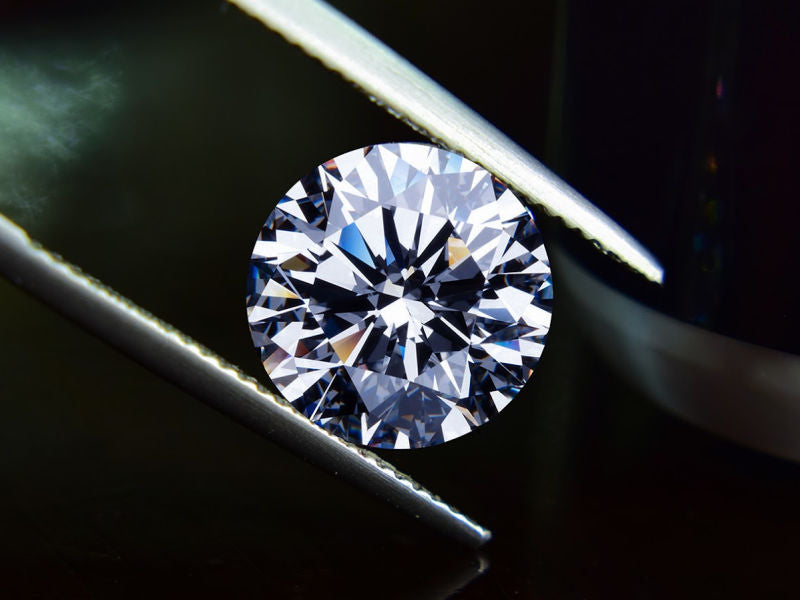 A diamond being held by tweezers