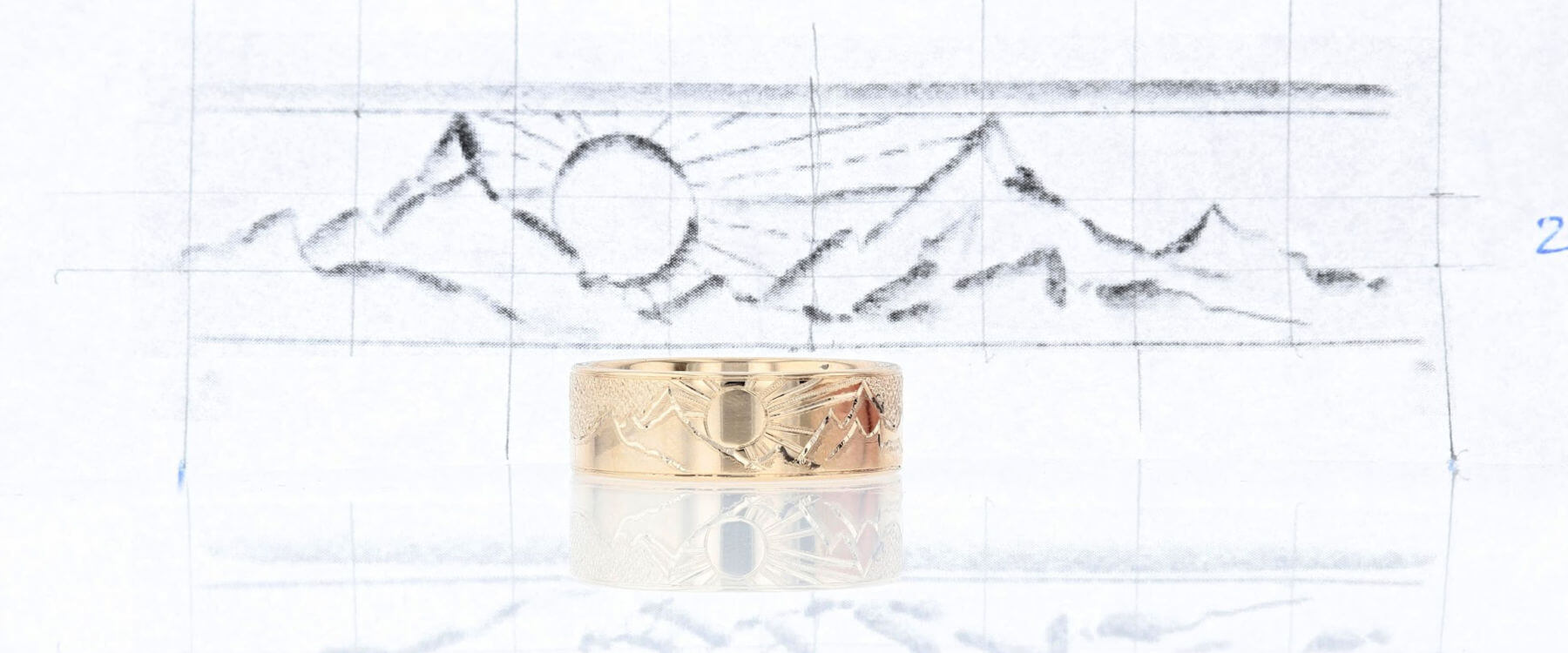 Yellow gold hand engraved ring with concept sketch behind it