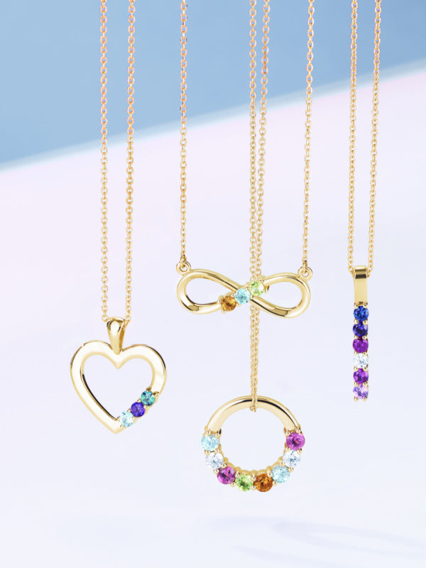 Shows mothers necklaces with different birthstones and quantities: one is a heart, one is infinity, one is a bar, and one is a circle
