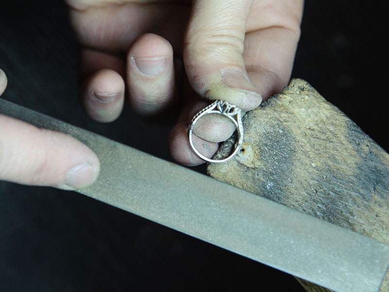 A ring being filed at a work bench