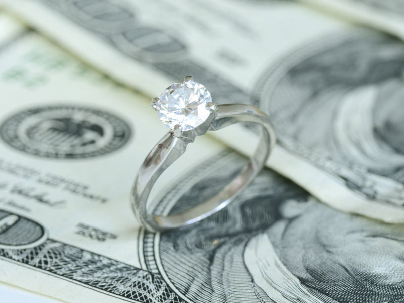 Lab grown diamond engagement ring on money