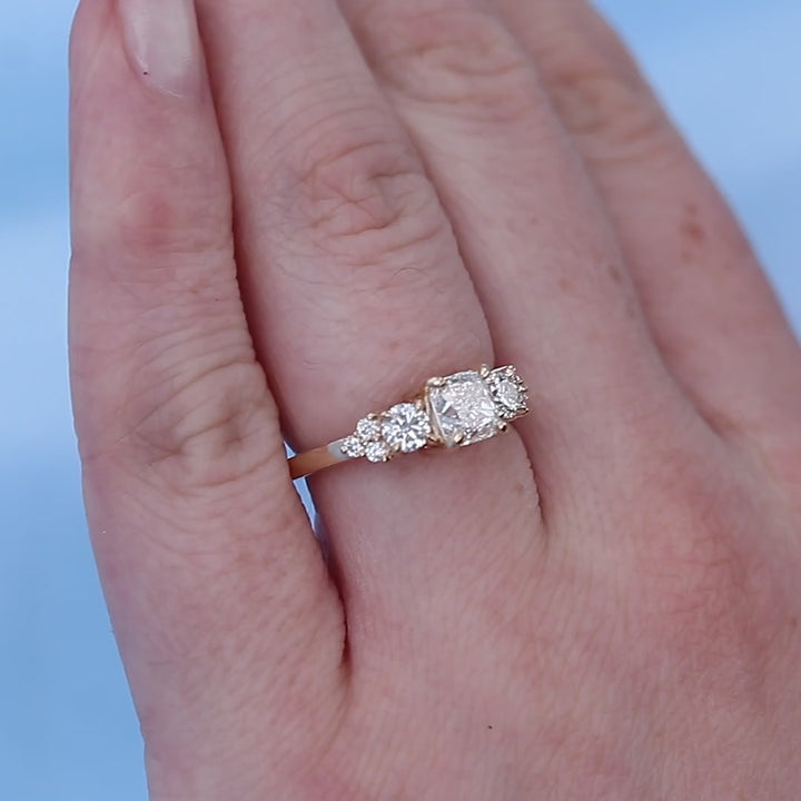 Cluster Three Stone Cushion Diamond Engagement Ring on a Finger