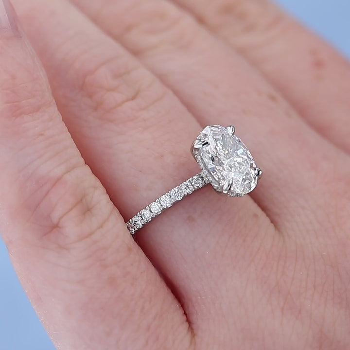 Platinum Hidden Halo Oval Diamond Engagement Ring on a Finger