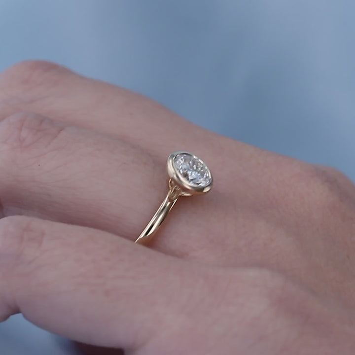 Video of a moissanite bezel solitaire in yellow gold