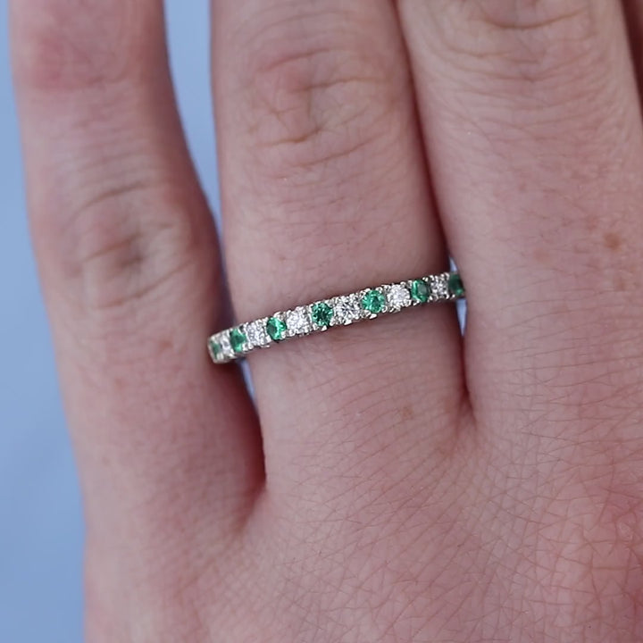 Emerald and Diamond Wedding Band on a Finger