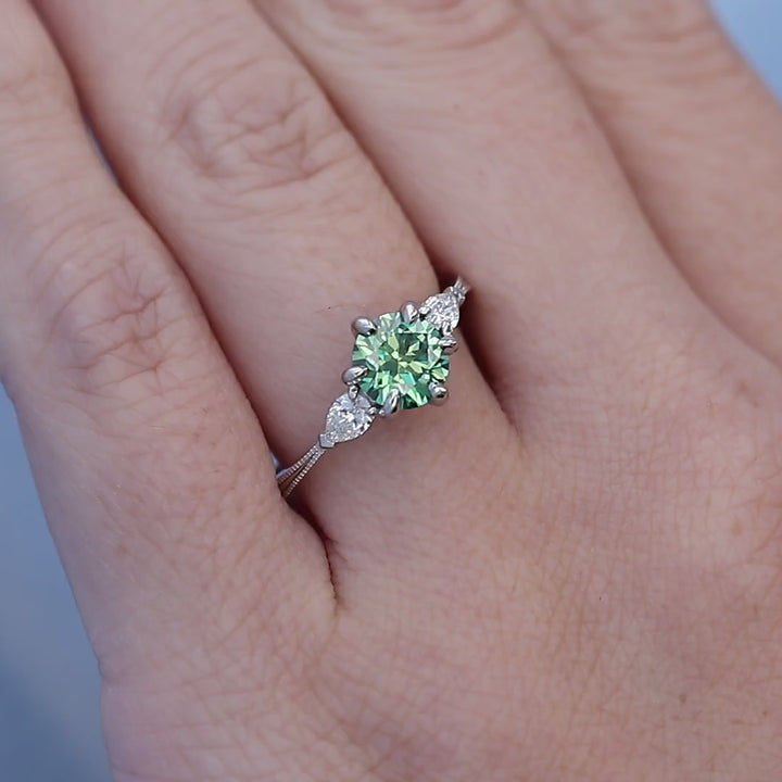 Green Moissanite Three Stone Engagement Ring on a Finger