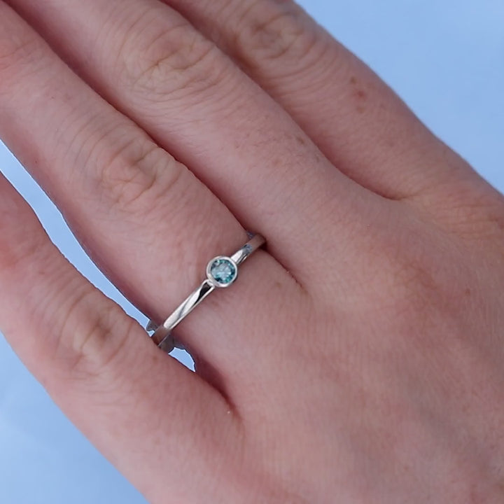 Blue Diamond Solitaire Ring on a Finger