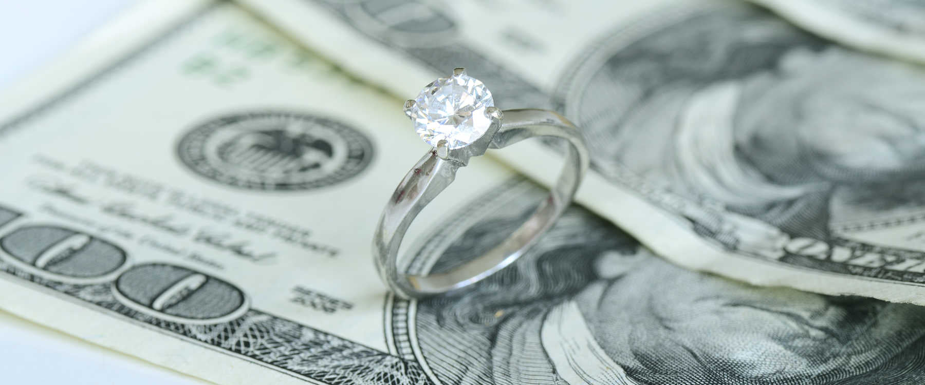 Diamond solitaire engagement ring on money