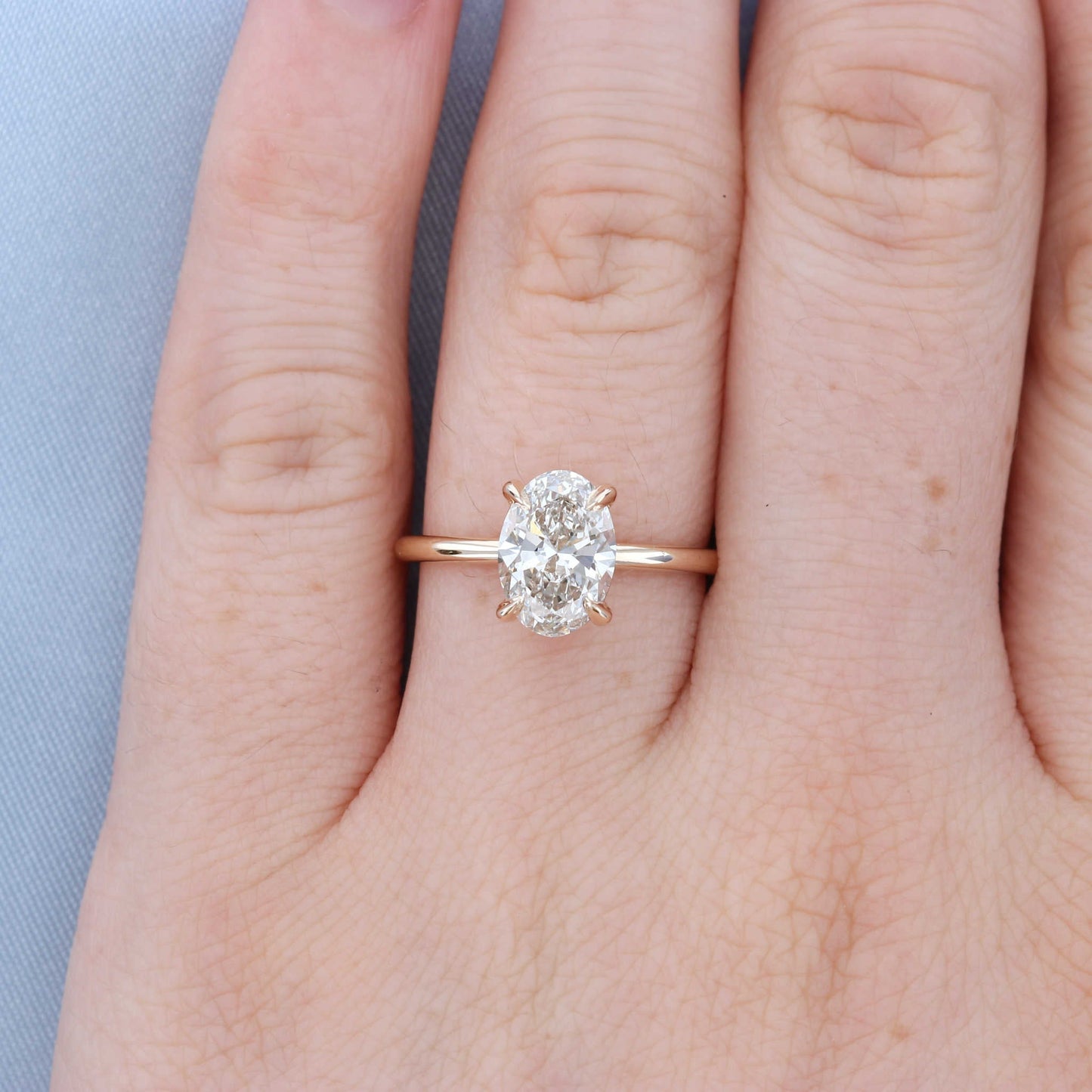 Oval Solitaire Diamond Engagement Ring on a Finger