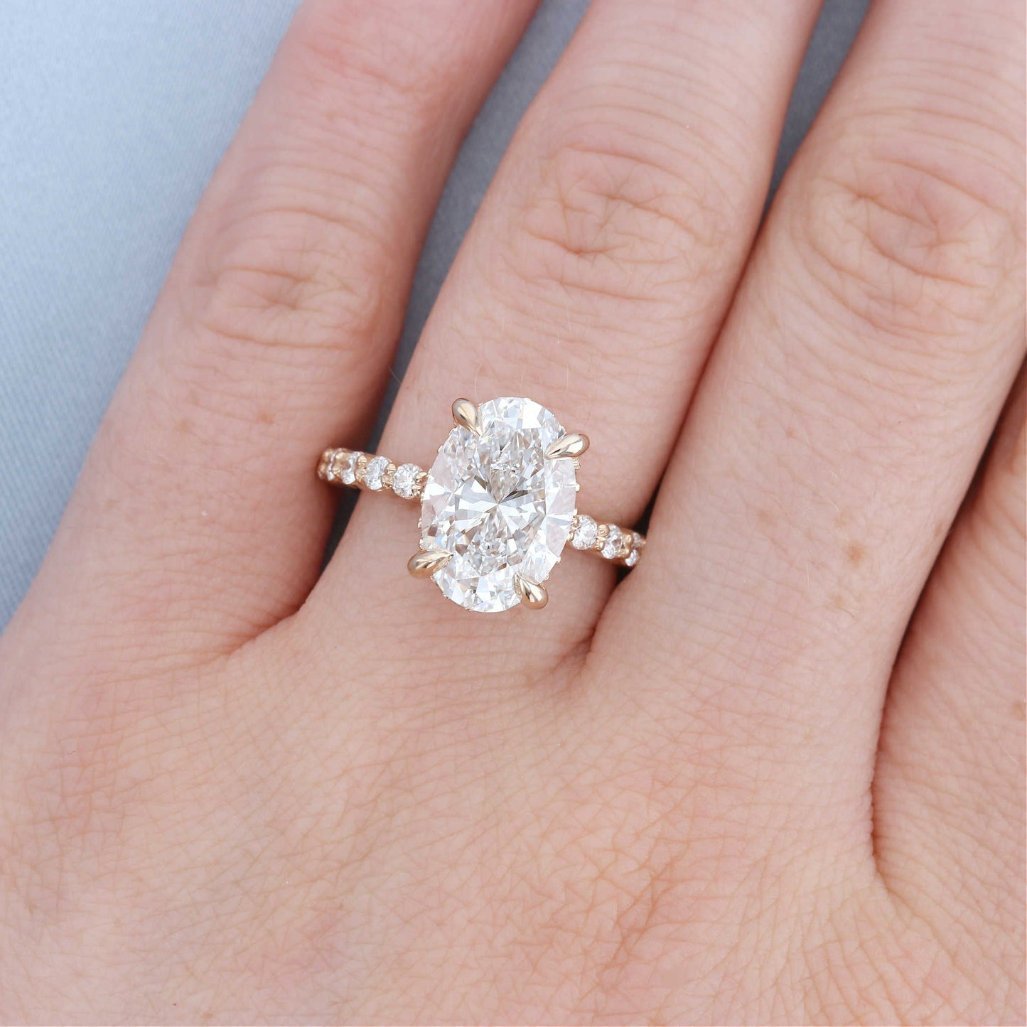 Hidden Halo Oval Diamond Engagement Ring on a Finger