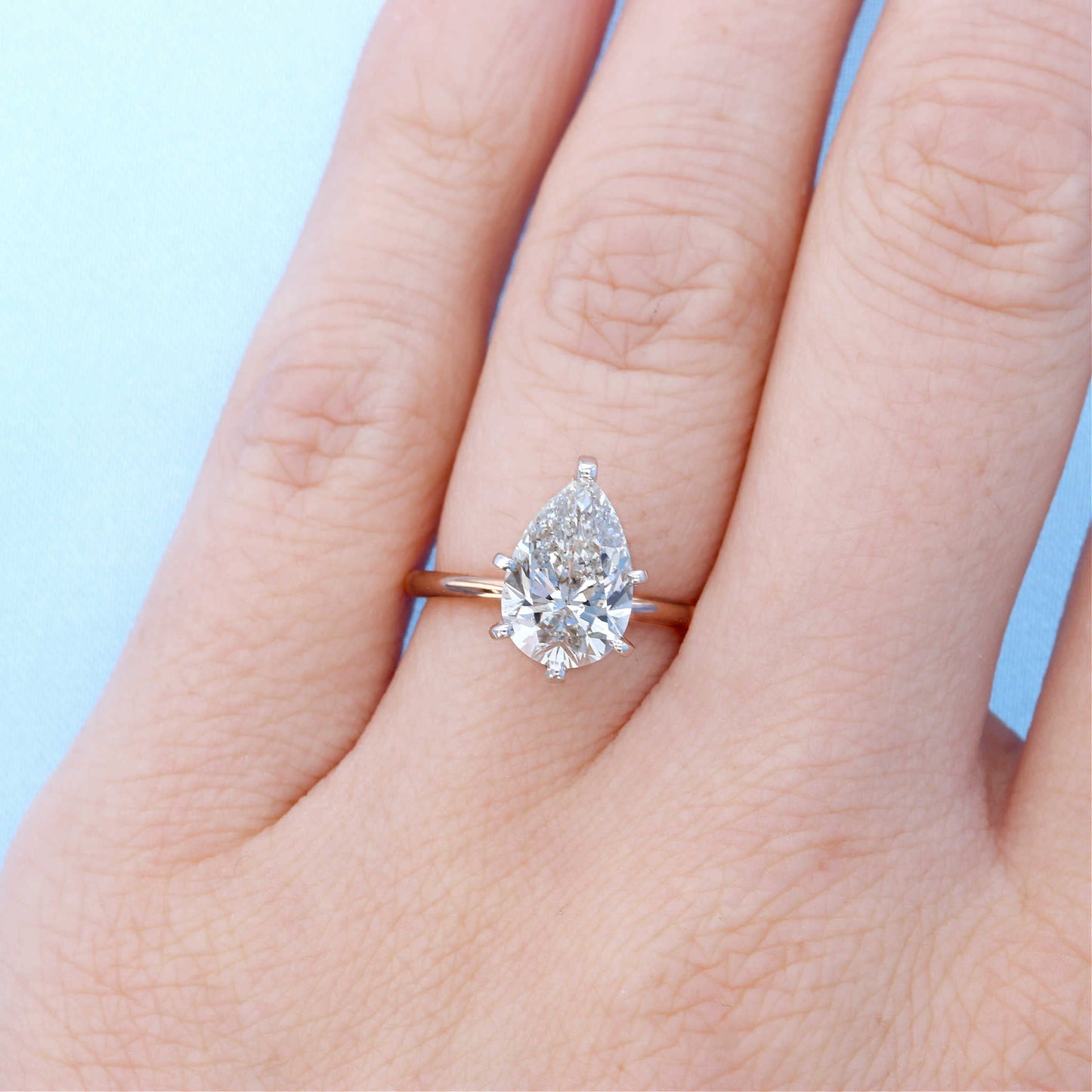Pear Solitaire Diamond Engagement Ring on a Finger