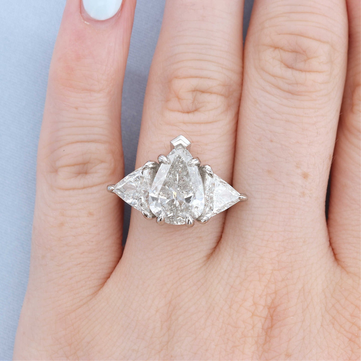 Platinum Three Stone Pear Diamond Engagement Ring on a Finger