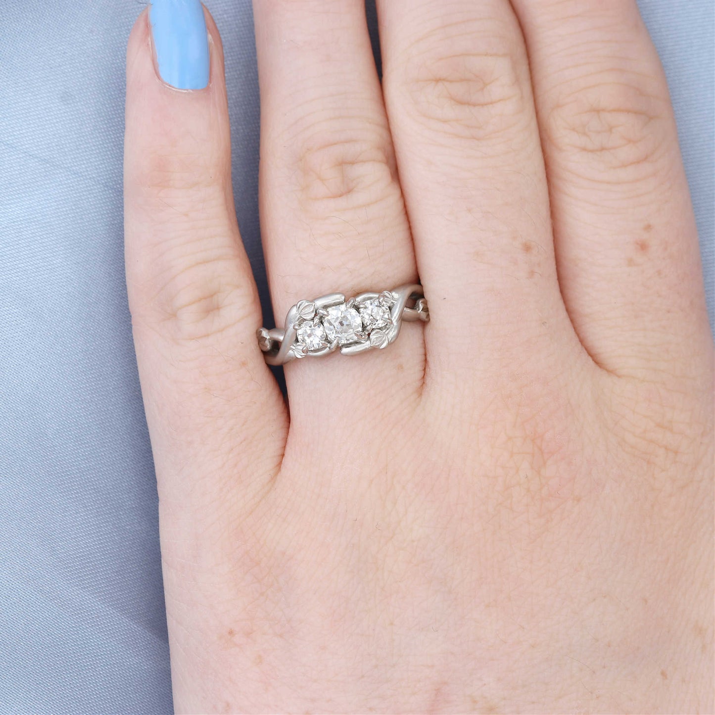 Three Stone Organic Diamond Engagement Ring on a Finger